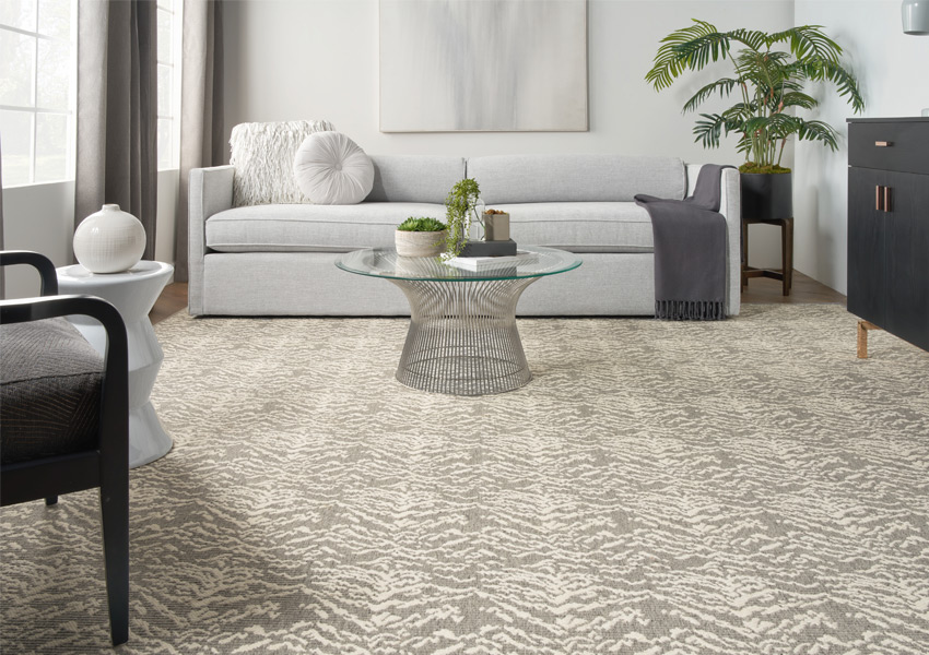 grey patterned carpet in living room with grey couch.